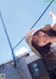 A young woman in a colorful hat smiles at the camera.