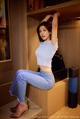 A woman sitting on top of a wooden shelf.