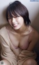 A woman in a pink bra sitting on the floor.
