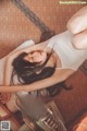 A woman laying on the floor next to a fan.